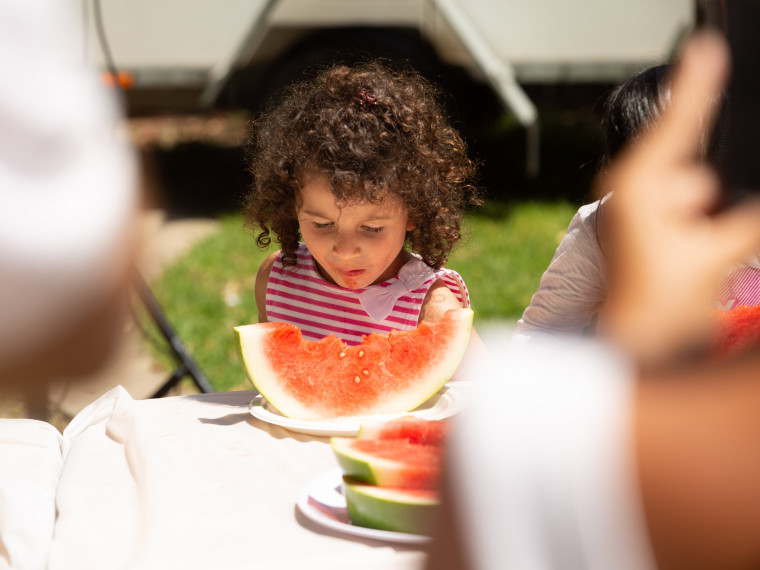 Young girl chomping down on watermelon during the competition at the Summer Playground in Darling Harbour