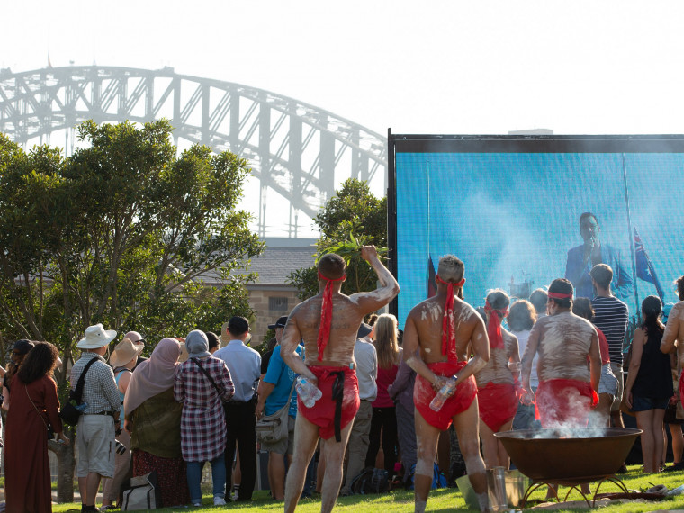 Crowd watching as Jason Owens sings the national anthem from the top of the Sydney Harbour Bridge