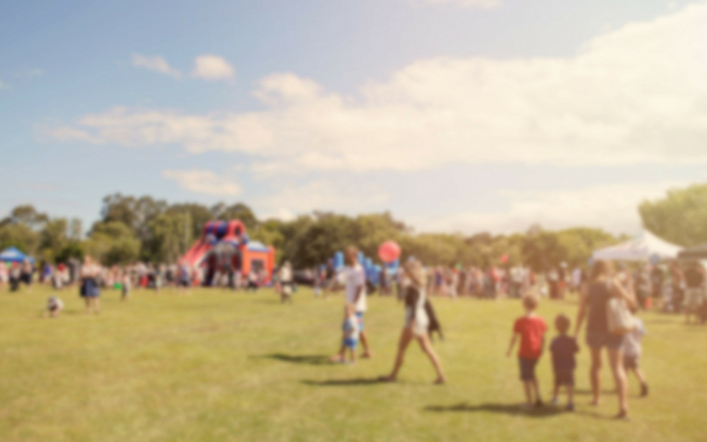 People walking through a park during a festival