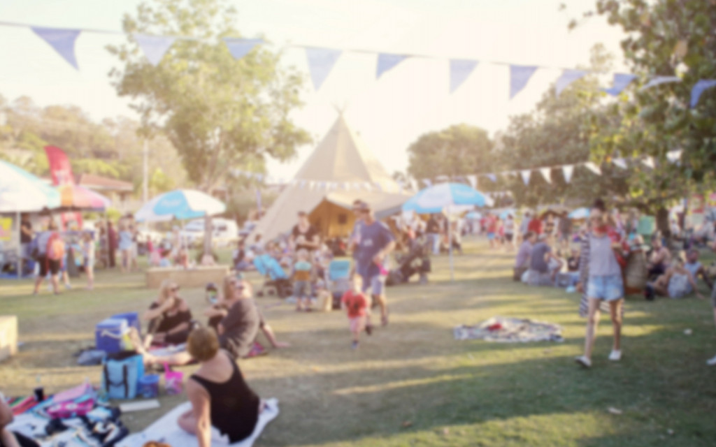 people having a picnic and walking around during a festival in a park