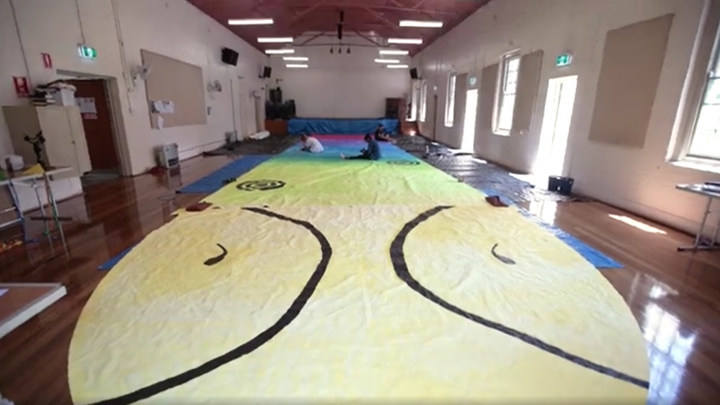 Artists from the KARI Foundation painting a kite